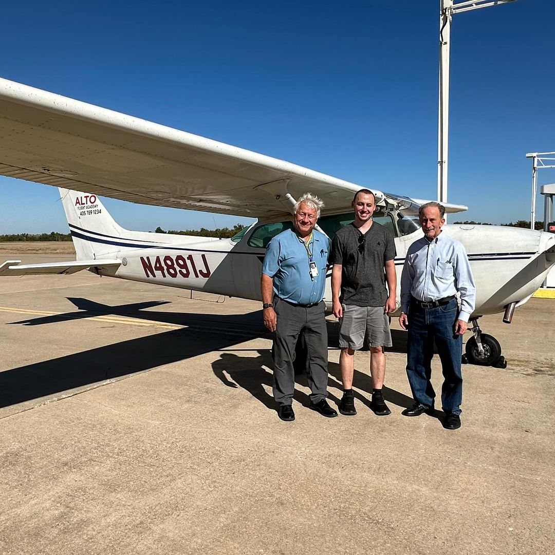 Student pilot in front of Cessna 172 after passing checkride in Yukon OK